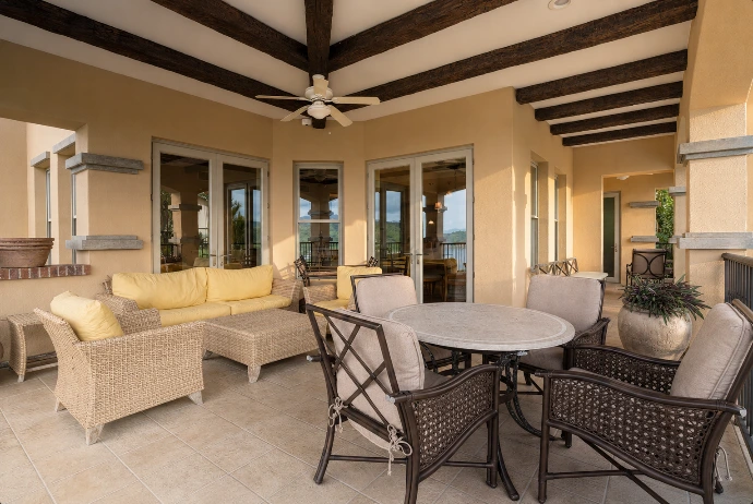 Covered outdoor living and dining terrace at Marbella 6D, featuring comfortable lounge seating and warm golden-hour light at Los Sueños Resort in Costa Rica.
