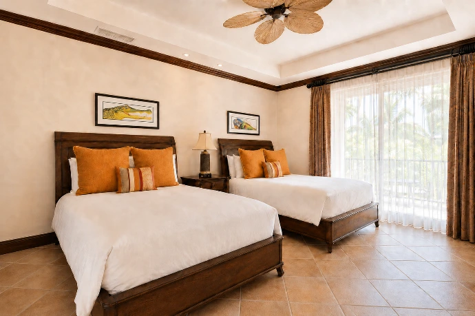 Double guest bedroom at Marbella 6D featuring two beds, distinctive iguana and crocodile artwork, and direct access to a tropical private balcony at Los Sueños Resort.