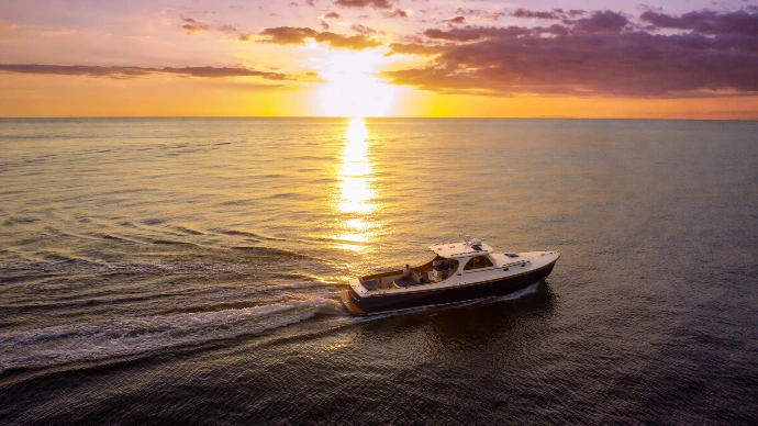 A private luxury yacht cruises across the Pacific at sunset after a curated day at Tortuga Island, Costa Rica.