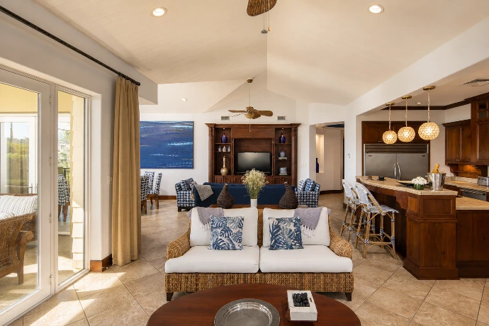 Open-plan living room and kitchen at Villa Tranquila, featuring refined blue accents, rich wood finishes, and spacious tropical interiors at Los Sueños Resort, Costa Rica.