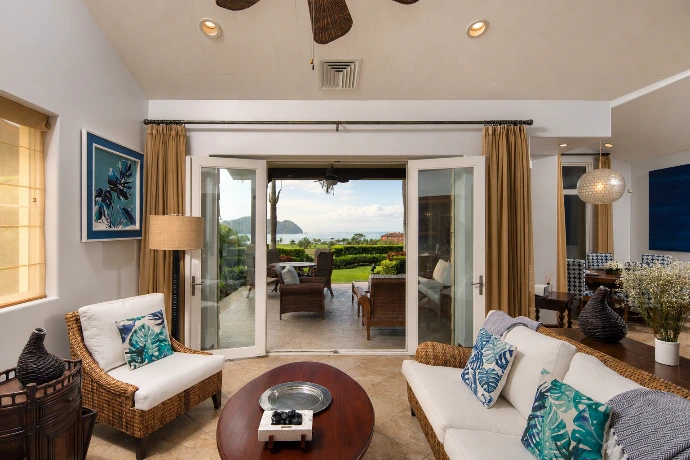 Open living room at Villa Tranquila overlooking the covered terrace, tropical gardens, and panoramic Pacific Ocean views in Vista del Sol at Los Sueños Resort, Costa Rica.