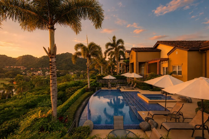 Semi-private pool and jacuzzi at Villa Tranquila, surrounded by tropical gardens and warm sunset light in Vista del Sol at Los Sueños Resort, Costa Rica.