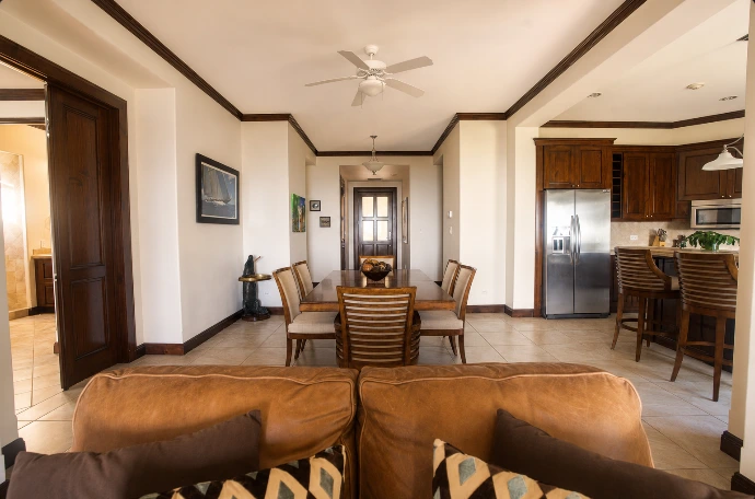 Elegant dining area and fully equipped kitchen at Altavista 1A, featuring warm natural light and refined tropical interiors at Los Sueños Resort, Costa Rica.