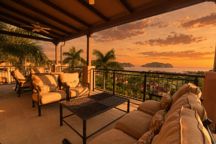 Covered terrace at Altavista 1A with elegant outdoor seating, panoramic Pacific Ocean views, and warm golden-hour light at Los Sueños Resort, Costa Rica.