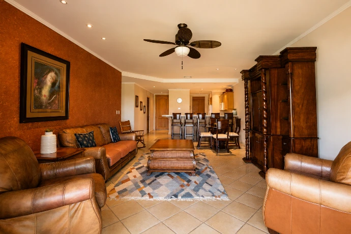 Bright open-plan living and dining area at Del Mar 2G, featuring warm tropical interiors, a fully equipped kitchen and spacious resort living at Los Sueños Resort, Costa Rica.
