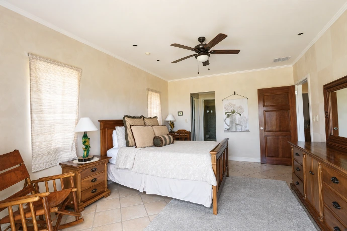 Inviting queen guest bedroom at Del Mar 2G, featuring warm wood furnishings, tropical-inspired details and a relaxed atmosphere at Los Sueños Resort, Costa Rica.