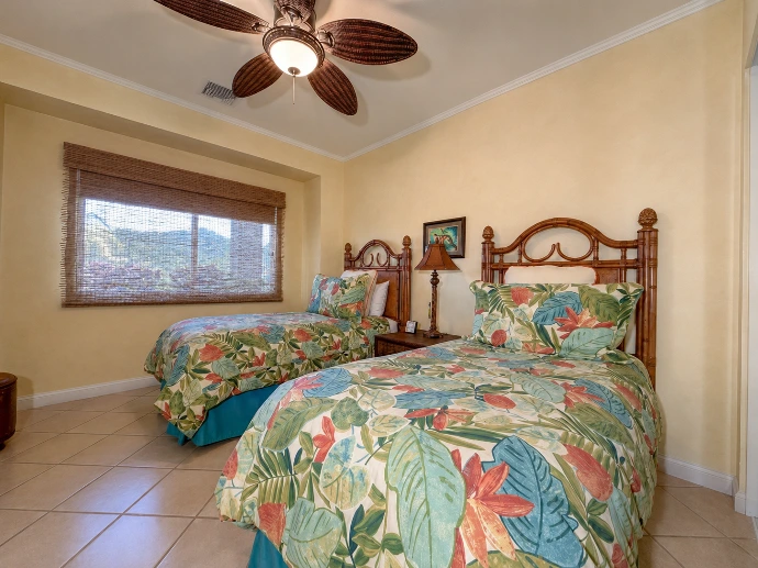 Comfortable twin bedroom at Del Mar 4P, featuring two beds, warm wood details and tropical-inspired décor within Los Sueños Resort, Costa Rica.