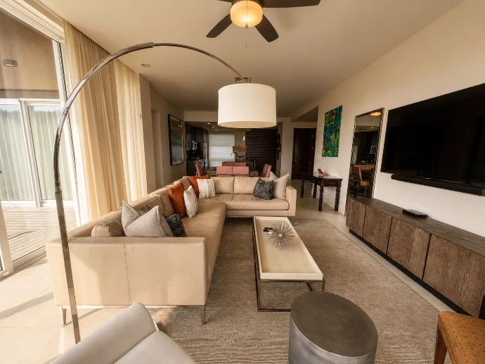 Warm open-concept living and dining area at Montecielo 5A, featuring contemporary furnishings and floor-to-ceiling windows in Los Sueños Resort, Costa Rica.