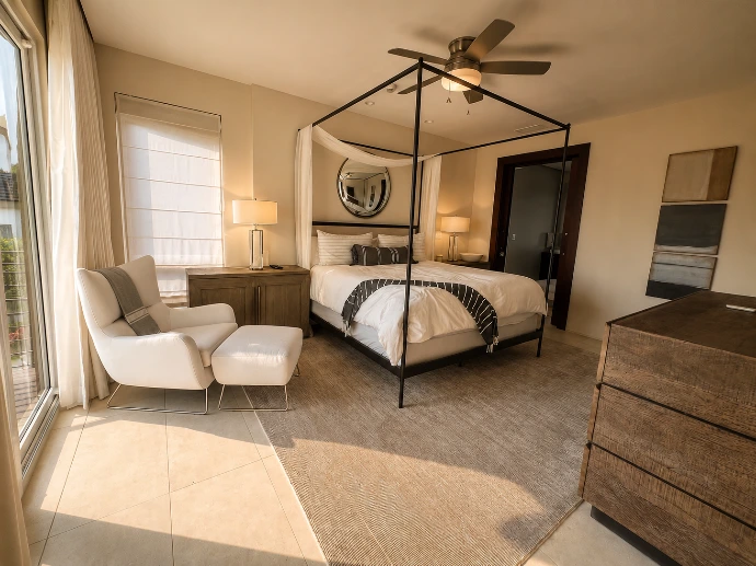 Serene primary bedroom at Montecielo 5A featuring a four-poster canopy bed, contemporary furnishings, and warm natural light in Los Sueños, Costa Rica.