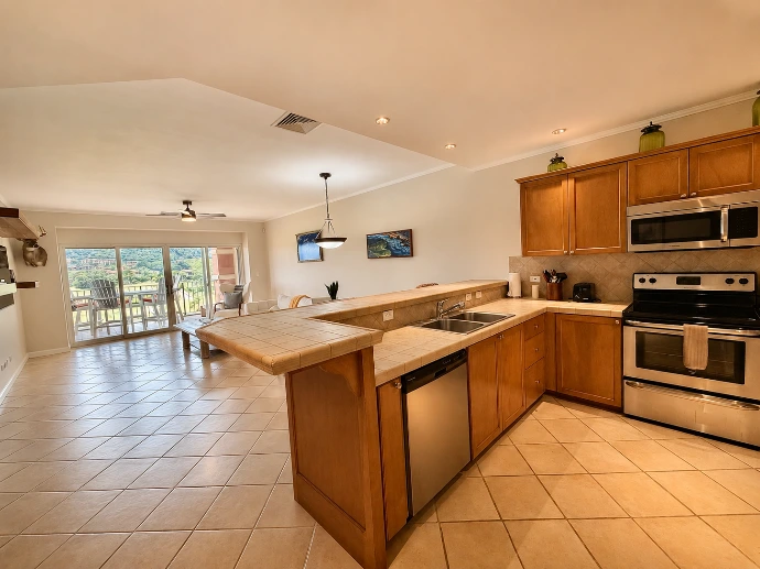 Open kitchen and living area leading to the balcony at Del Mar 4D in Los Sueños Resort.